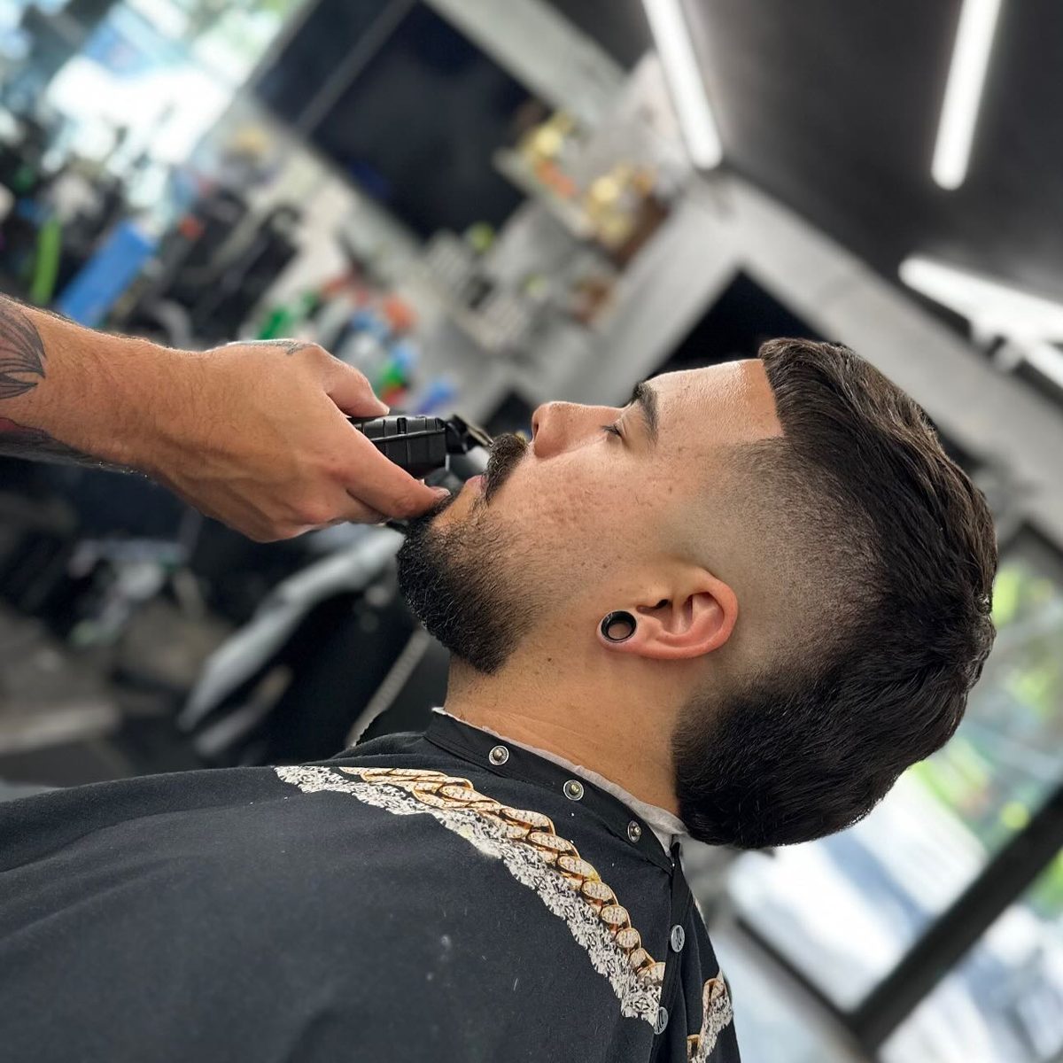 Barber detailing a client's beard and fade in the chair