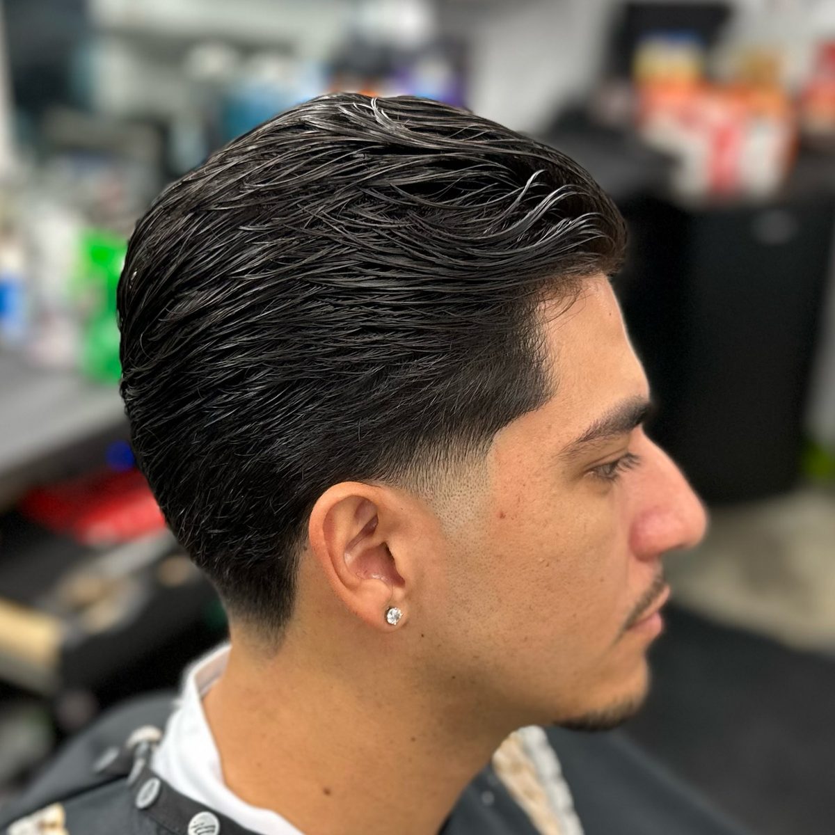 Side profile of a client with a slicked-back taper haircut